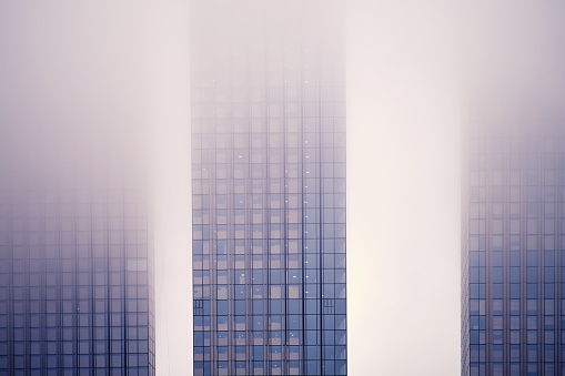 Windows of skyscrapers in the fog, background copy space. Metal structures with windows of a high-rise building in smog, close-up