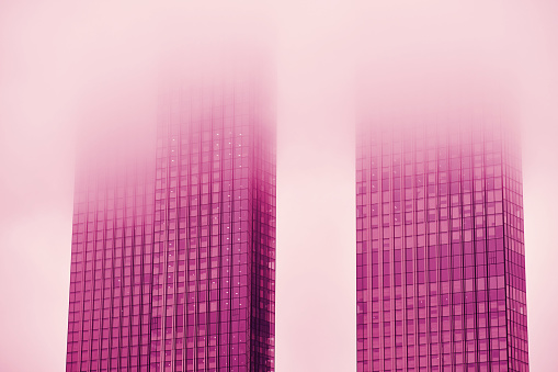 Windows of skyscrapers in the fog, background copy space. Metal structures with windows of a high-rise building in smog, close-up