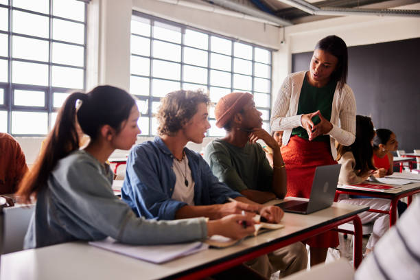 istock Teacher talking with a group of diverse students in a classroom 1440718317