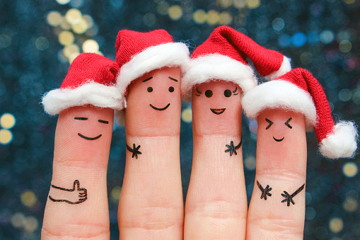 Fingers art of friends celebrates Christmas. The concept of a group of people laughing in new year hats.