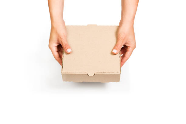 istock Woman holding a brown cardboard box with both hands on a white background 1440719521