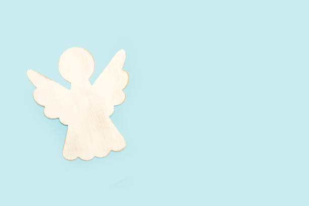 istock A white wooden angel on a light blue background 1440719542