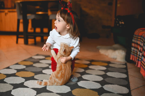 istock child playing with a cat at home. 1440719610