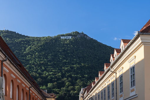 City name Brasov written with huge white letters on top of forested Mount Tampa is a recognizable city sign, Romania