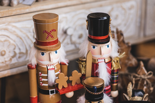 Antique Nutcracker Drummer with a red drum. He has white hair and beard. He sports a black hat, with a blue coat and black boots. The point of view is straight on, and is isolated on a white background.