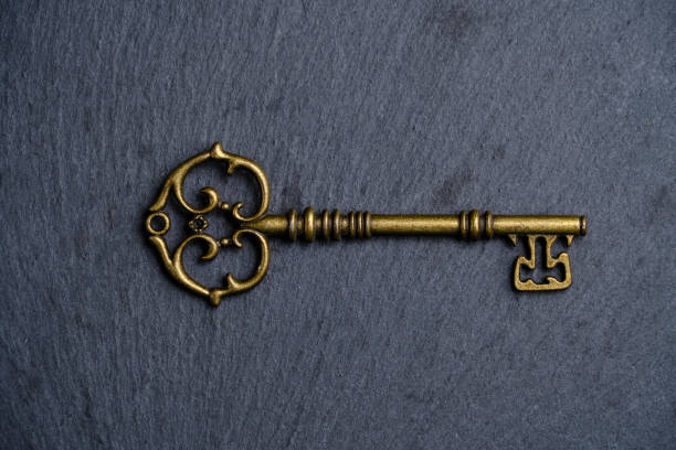 istock Old vintage key dark slate stone background. 1440724426