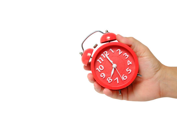 istock Red alarm clock in hand on a white background. 1440724484