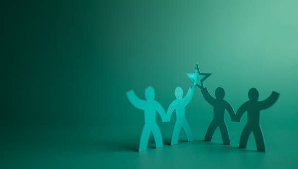 Successful Teamwork Concepts. Paper Cut as Group of Worker Raise Up a Star Together. Business Strategy. Working to Committed and Towards a Shared Goal. Colleagues or Partnership Celebrating a Success stock photo