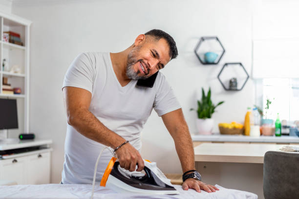 istock A  man at home ironing his button down shirt. 1440726983