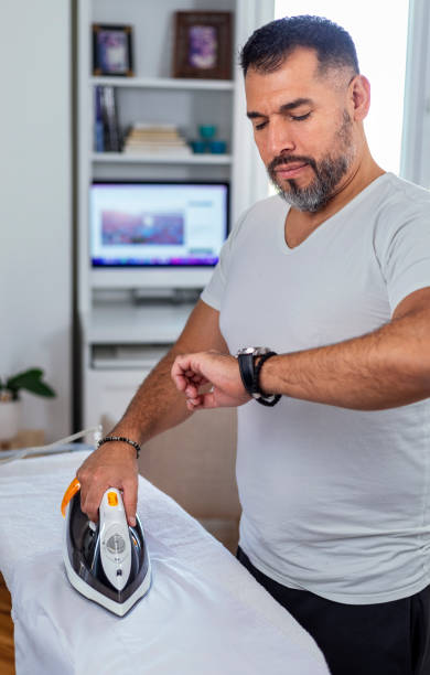 istock A  man at home ironing his button down shirt. 1440726996
