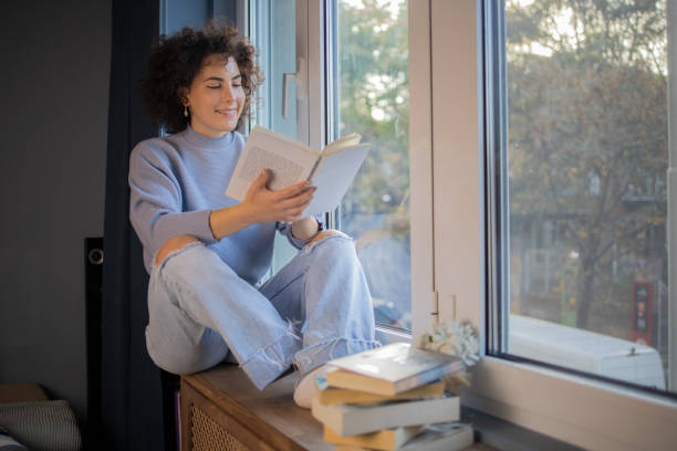 istock Happy woman reading book at home 1440727046