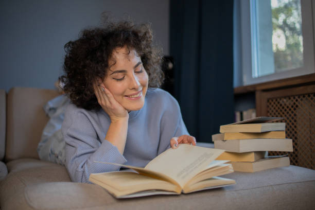 istock Happy woman reading book at home 1440727076