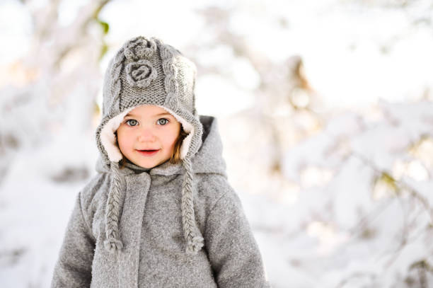 mała dziewczynka cieszy się feriami zimowymi. - winter child coat baby girls zdjęcia i obrazy z banku zdjęć