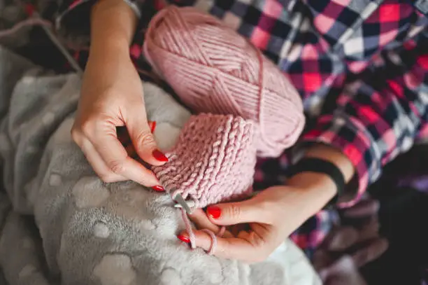 Female hobby knitting. Close up of woman hands knitting. Handmade gift