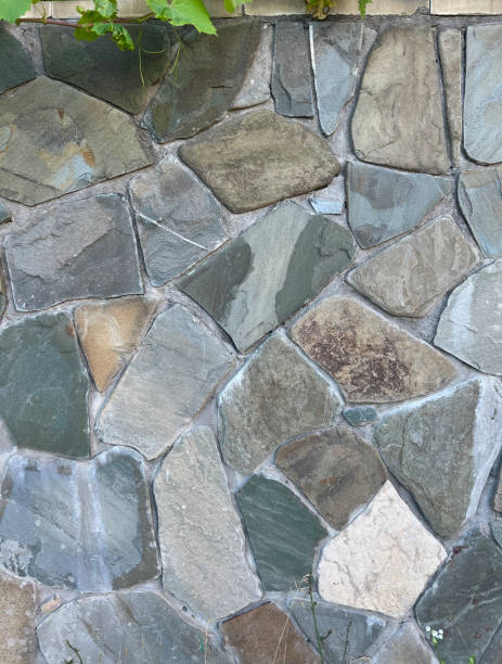 gray stone wall background, stones of different sizes and shapes - antique old fashioned close up color image imagens e fotografias de stock