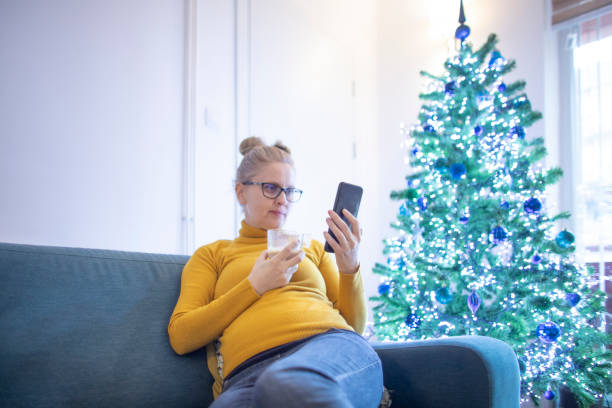 istock Pregnant woman using smart phone during Christmas 1440732548