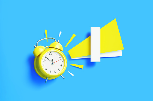 Number one sitting next to yellow alarm clock on blue background. Horizontal composition with copy space.