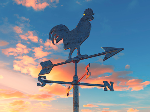 A regular metal wind cock weathervane with a cockeral motif facing on a dawn sky background - 3D render