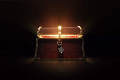 Glowing treasure chest on white background. Horizontal composition with copy space. Low angle view.