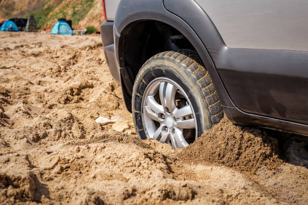 istock Car wheel stuck in sand 1440737059