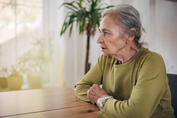 istock Elderly woman sitting at the dining table alone at home 1440737801