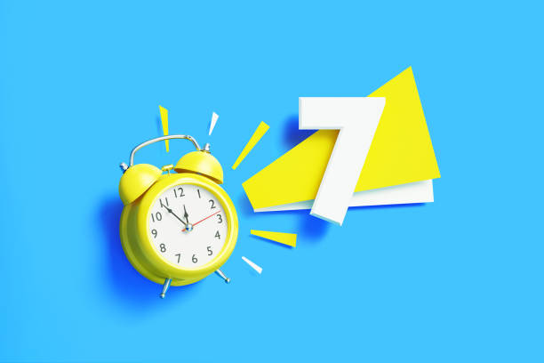 istock Number Seven Sitting Next To A Yellow Alarm Clock On Blue Background 1440738259