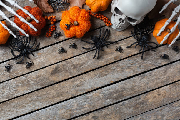istock Halloween greeting card with pumpkin, skulls, bony hands and leaves 1440738658