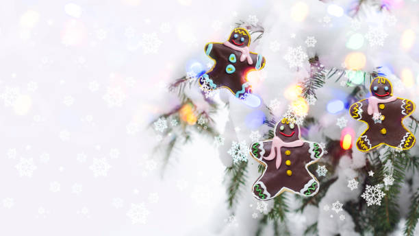 Christmas concept with gingerbread men on the background of a defocused Christmas tree and bokeh stock photo