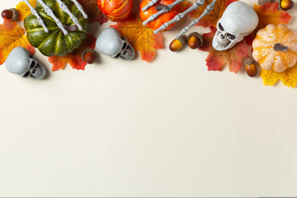 istock Halloween greeting card with pumpkin, skulls, bony hands and leaves 1440740431
