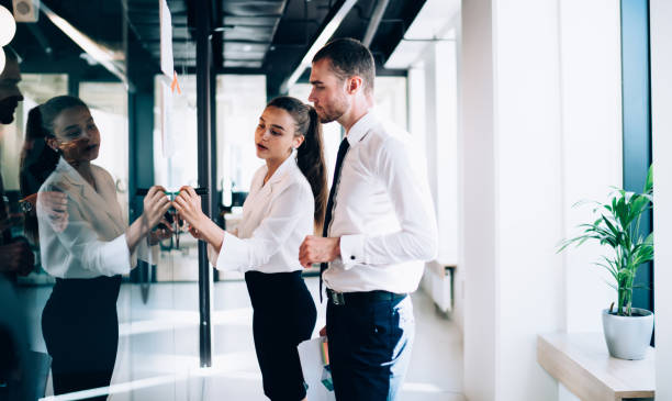 istock Focused woman and man writing on transparent wall 1440742465