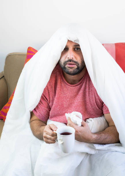 istock Sick man with flu and coronavirus covered with the blanket 1440745681