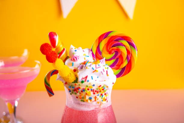 caramel milk shake cocktail lemonade with whipped cream and colored sweet candy and lollipops in glass. - flavored ice variation birthday candy imagens e fotografias de stock