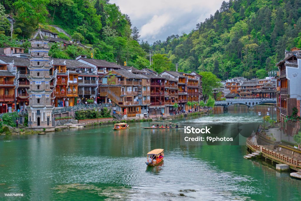 Feng Huang Ancient Town Phoenix Ancient Town , China Chinese tourist attraction destination - Feng Huang Ancient Town (Phoenix Ancient Town) on Tuo Jiang River with Wanming Pagoda tower and tourist boats. Hunan Province, China Ancient Stock Photo