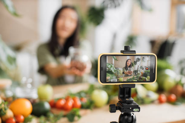 Attractive female holding hazelnuts while recording blog.