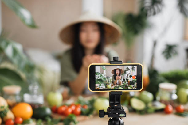 istock Beauty asian blogger in traditional conical hat using coconut to make smoothies for breakfast 1440748981