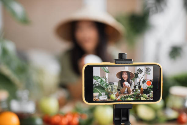 istock Beauty asian blogger in traditional conical hat using coconut to make smoothies for breakfast 1440748985