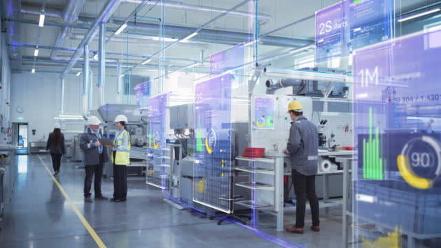 Factory Digitalization: Two Industrial Engineers Use Laptop Computer, Big Data Statistics Visualization, Optimization of High-Tech Electronics Facility. Industry 4.0 Machinery Manufacturing Products