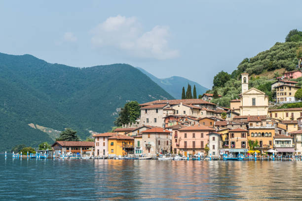Landscape of the lakeside of Peshiera Maraglio in Monte Isola with beautiful colored houses reflecting in the water stock photo