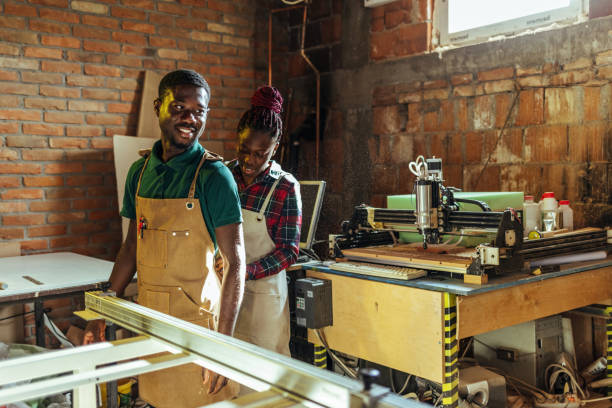 istock Couple tying apron at at work during the day in their workshop. 1440752523