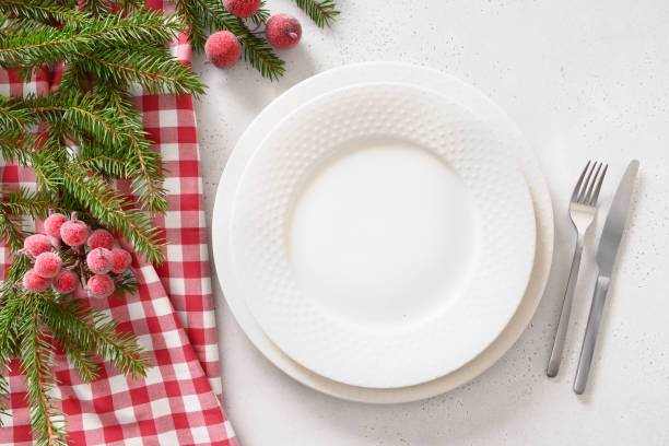 Christmas table setting with elegant red decorations on white table. View from above.