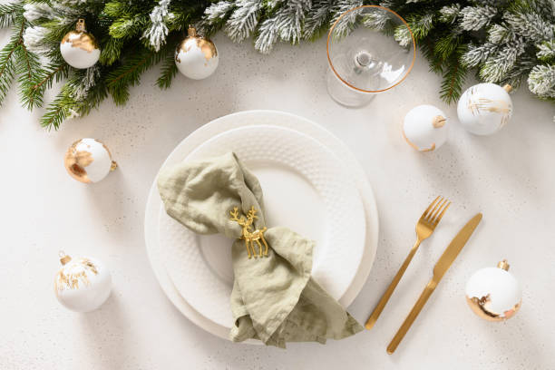 istock Beautiful Christmas festive table setting with white plate, golden balls on white. 1440753367