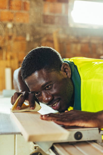 Carpenter restoring a wood with sand paper.