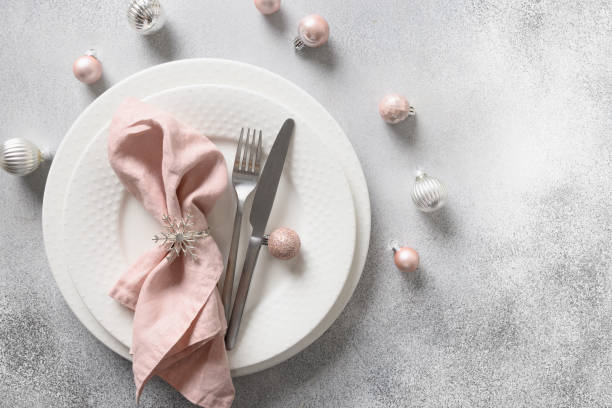 istock Christmas festive table setting with pink ball and napkin on gray table. 1440754263