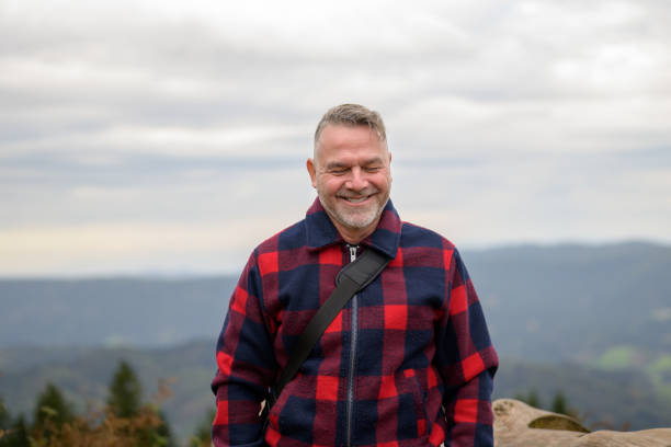 istock Laughing man is standing on a mountain 1440755009