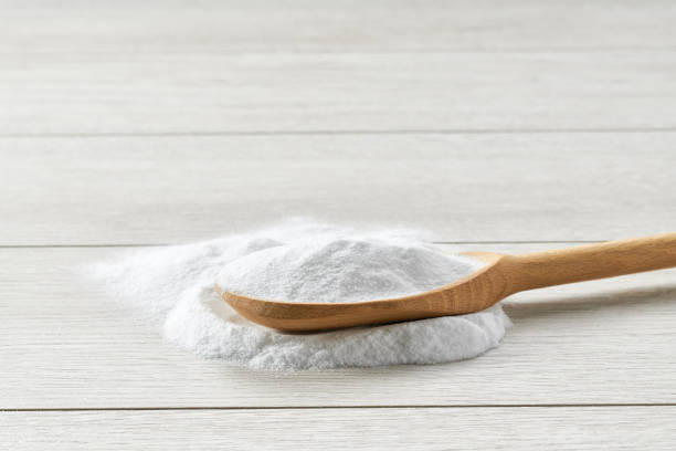 istock Sodium bicarbonate in a wooden spoon on a light wooden table. 1440760337
