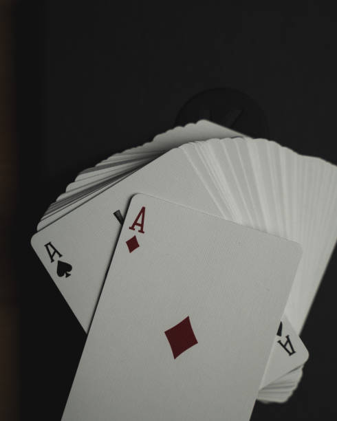 istock Top view closeup of the playing cards displayed on a black table 1440760412