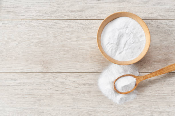 istock plate with baking soda on wooden table, top view. 1440760723