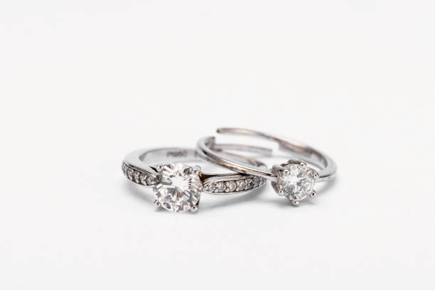 istock Closeup shot of two diamond rings on a white surface 1440761316