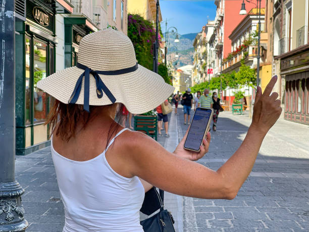 Adult woman using maps on her phone on the streets of Sorrento, Italy sorrento, Italy – August 09, 2021: An adult woman using maps on her phone on the streets of Sorrento, Italy amalfi coast map stock pictures, royalty-free photos & images