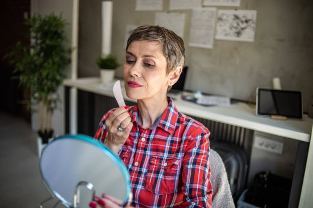 mujer caucásica madura usando piedra gua sha para masaje facial de cuarzo rosa - quartz caucasian one person energy fotografías e imágenes de stock